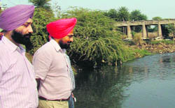 Deputy Commissioner Tejinder Pal Singh Sidhu inspects the site allocated for a new bridge at Jagatpura village on Wednesday. 