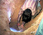 A worker digs a pit to exhume the victim's body