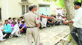 Farmers sit in a queue to get subsidised barseem seed in Kaithal on Thursday.