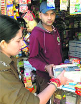 ASP Soumya seizes cigarette packs from a shop outside HPU in Shimla on Thursday.