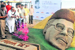Maharashtra PWD Minister Chhagan Bhujbal pays tributes to a sand sculpture of legendary singer Manna Dey, created by sand artist Sudarsan Pattnaik, at Girgaon Chowpaty in Mumbai on Thursday.  PTI