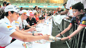 Force India drivers Adrian Sutil and Paul di Riesta give autographs to motorsports lovers on Thursday.