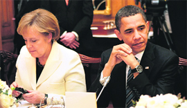 German Chancellor Angela Merkel looks at an electronic device as she sits next to US President Barack Obama in London.