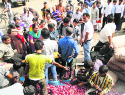People stand in a queue to buy onion from a government stall at the Grain Market, Sector 26, in Chandigarh on Friday. Tribune photo: Pradeep Tewari
