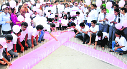 Students light candles on the pink ribbon during a breast cancer awareness drive at Sector 17 in Chandigarh on Friday. Tribune photo