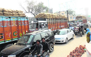 Vehicles stranded near the grain market as farmers block traffic at Fatehabad on Friday. 