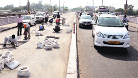 Labourers busy in repairing the flyover in Jammu on Friday.