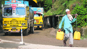 An old man carries drinking water on his shoulder near the Jammu-Srinagar national highway on Friday.