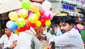 A balloon seller waits for a customer at Purani Mandi market in Jammu.
