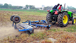 A tractor in operation on shamlat land in Therhi village near Urban Estate in Patiala on Friday
