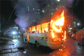 A bus set on fire by protesters in Dhaka on Monday. 