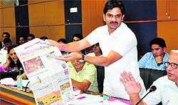 Ravi Kant Swami, councillor from Ward No. 13, shows a report on garbage menace in Panchkula published in Chandigarh Tribune to other members during the MC meeting at the DC Office complex in Panchkula on Saturday