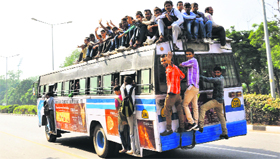 Students sit atop a bus after a railway recruitment exam on the road separating Sectors 16 and 17 on Sunday.
