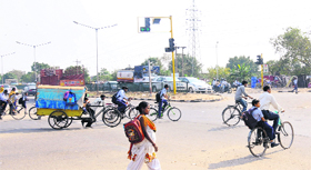 risking their lives, schoolchildren cross a road at the Sectors 44/45 junction.