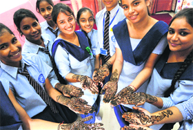 Girls show their hands bearing beautiful mehndi designs after a competition at a government school in Chandigarh.
