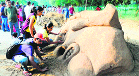 artists design a sand sculpture at the Chandigarh Street Art and Food Festival at Sukhna Lake in Chandigarh on Sunday.
