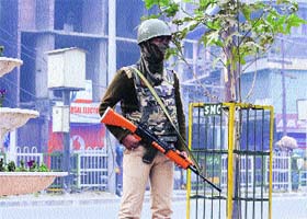 A CRPF man stands guard during a strike in Srinagar on Sunday