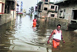 Residents of Raghunath Pur, on the outskirts of Bhubaneshwar, cross a waterlogged road on Sunday