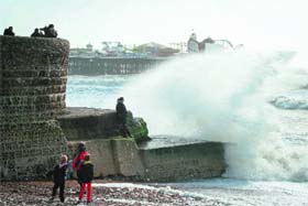 In the eye of storm: Large waves break against barriers on the seafront in Stratfort on Sunday
