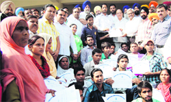 Local Bodies Minister Anil Joshi, Mayor Bakshi Ram Arora and others hand over the letters of appointment during a function at Ram Bagh Garden in Amritsar on Monday. A Tribune Photograph 