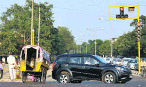 A school cycle rickshaw jumps a red light signal on the road separating Sectors 44 and 45 on Monday.