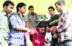 Members of Berojgar Diploma Ayurvedic Pharmacists Assocation help a fellow protester, who fainted during the dharna outside Hindi Bhawan in Dehradun on Monday. Tribune photo: Vinod Pundir