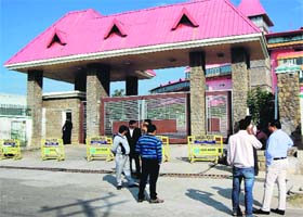Cricket fans stand at the main gate of the HPCA stadium in Dharamsala on Monday