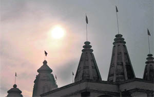 A panoramic view of temples in the backdrop of a sun covered by clouds at Shastri Nagar in Jammu on Monday.