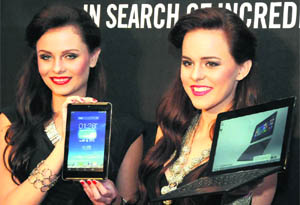 Models pose with Asus Transformer book T100 and Fonepad 7 during their launch in New Delhi on Tuesday.