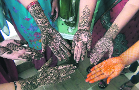 Girls show mehndi designs at a competition in Nalanda College of Education in Dehradun on Tuesday.