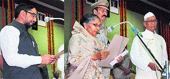 Governor Jagannath Pahadia (right) administers the oath to Savitri Jindal and Aftab Ahmed as ministers in Chandigarh on Tuesday