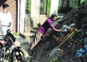 An employee of nagar panchayat cleans an engraved rock at Rewalsar