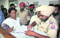 Ravinder Kaur, who was duped of Rs 2 lakh by an impostor at the State Bank of India, reports the matter to the police at the bank in Jalandhar on Tuesday.