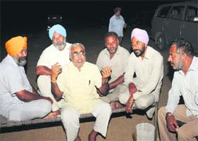 Schoolteacher Narendra Jadeja (centre) with Punjabi farmers in Parjan village