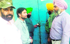 Officials of the House Tax Department of the Municipal Corporation seal a shop in Amritsar on Wednesday. A Tribune photograph