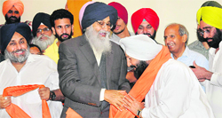 Chief Minister PS Badal welcomes Congress leader Avtar Singh Brar to the party fold with a siropa on Wednesday. On his left is Deputy CM Sukhbir Badal. Tribune photo: Manoj Mahajan
