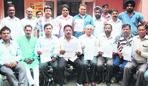 MC employees show their written agreement with the civic body about the formers long-pending demands, in Amritsar on Thursday. 