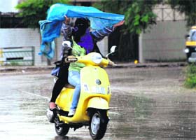 Girls save themselves from rain in tricity on Thursday