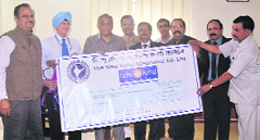 Officials of The New India Assurance Co present a cheque for Rs 1 crore to Chief Minister Vijay Bahuguna in Dehradun on Thursday. A Tribune photograph