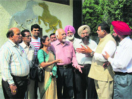 Social workers protest the reported move to demolish Pash library in Karnal on Thursday.