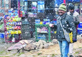Tourists enjoy the first snowfall of the season in Gulmarg on Thursday