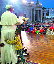 A boy hugs Pope Francis while he addresses a crowd at St Peter's square in the Vatican on the occasion of Family Day