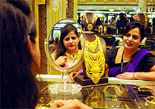 A woman buys gold jewellery at a shop in the Karol Bagh market on the occasion of Dhanteras in New Delhi on Friday