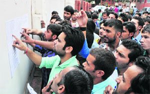 Paramedical students search for their roll numbers before entering the examination hall in Government College for Women, Parade, in Jammu on Friday.