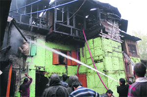 Firefighters douse flames at Rambagh in Srinagar on Friday