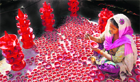 A woman paints earthen lamps.