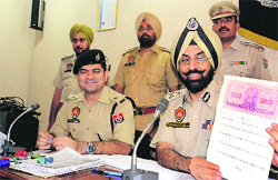 Police Commissioner Paramjit Gill shows a fake registry in Ludhiana on Friday. Photo: Inderjeet Verma
