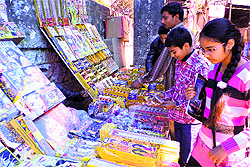 Children purchase crackers from a shop on the eve of Diwali festival in Mussoorie on Saturday