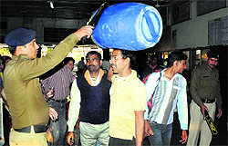 Policemen check luggage of passengers at Dehradun Railway Station on Saturday