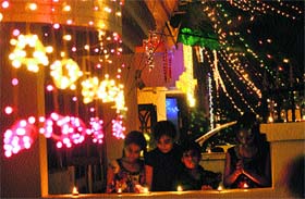 Children light diyas on the eve of Diwali in Karnal on Saturday